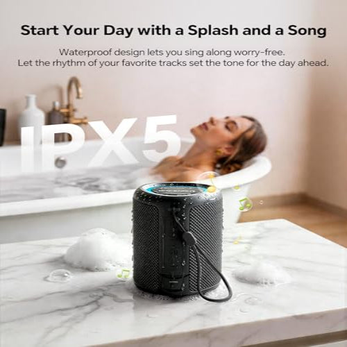 Black waterproof Bluetooth speaker on a marble surface with a woman in a bathtub in the background.