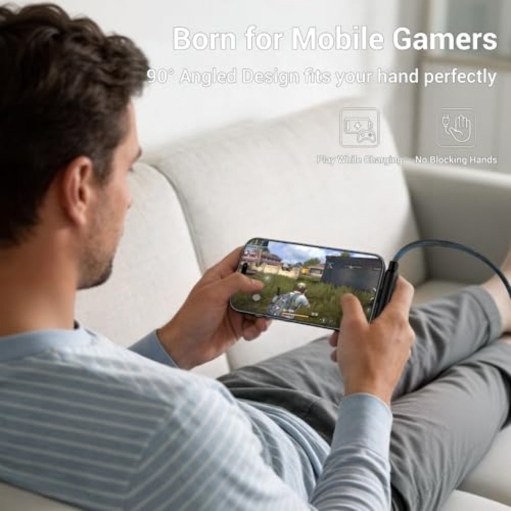 Man playing a game on a smartphone with a gaming accessory, sitting on a couch.