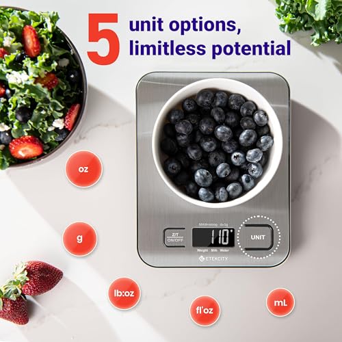 Digital kitchen scale with a bowl of blueberries on a white surface, surrounded by fruits and vegetables.
