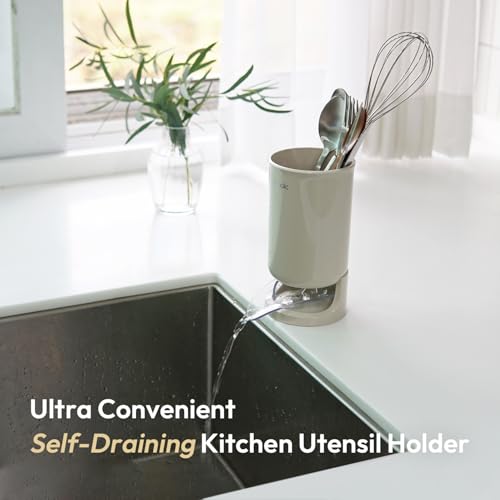 Kitchen utensil holder with utensils on a kitchen counter next to a sink.
